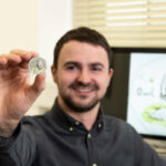00-The Royal Mint designer Dan Thorne with the official Owl 50p coin in the Winnie the Pooh collection inspired by Disney